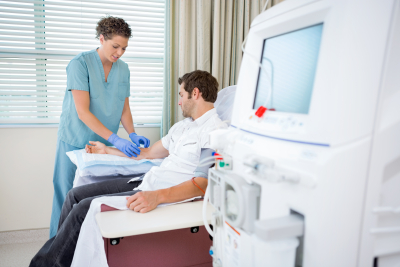 nurse injecting patient for renal dialysis treatment in hospital room